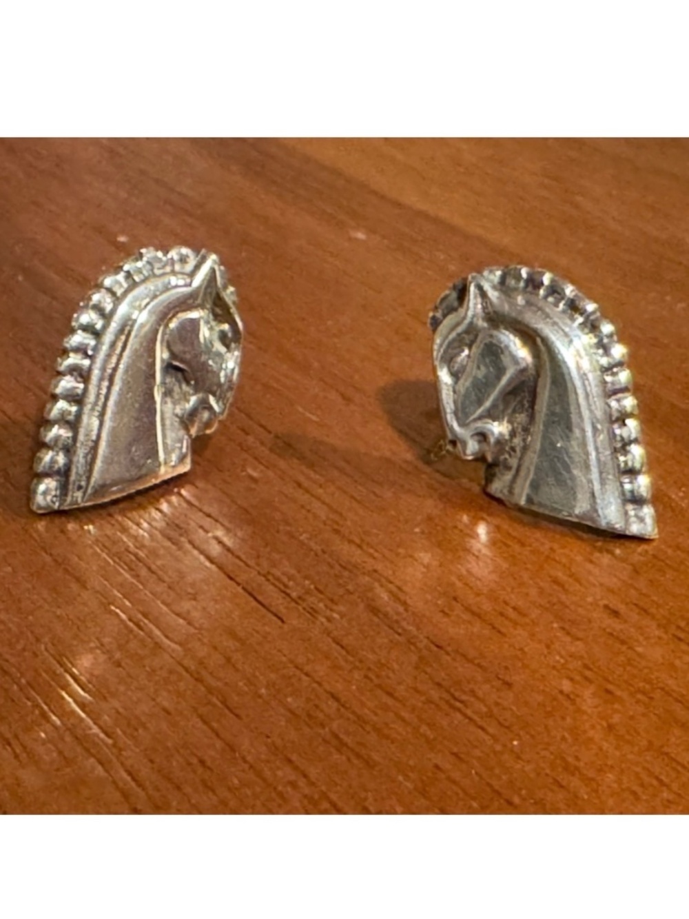 Silver horse head earrings.